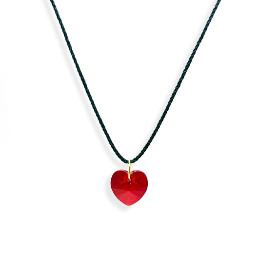 This stunning Swarovski red heart pendant is the perfect way to express your affection. The sparkling red crystal is accentuated by a lovely black thread, making it an eye-catching piece of jewelry. Whether you're gifting it to a loved one or treating yourself, this pendant will make a special statement. 11:11 collection, Ace Studio